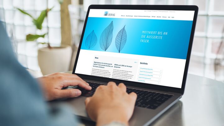 Person tippt auf einem Laptop mit der Webseite „MOTIVIERT BIS AN DIE AUSSERSTE FASER“
