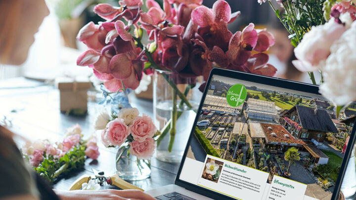 Laptop mit Webauftritt Blumen Grütter und Blumen im Hintergrund