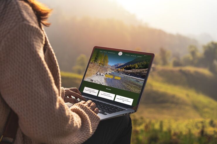Frau bedient Laptop mit geöffneter Webseite Wald und Klima Verein Ursern
